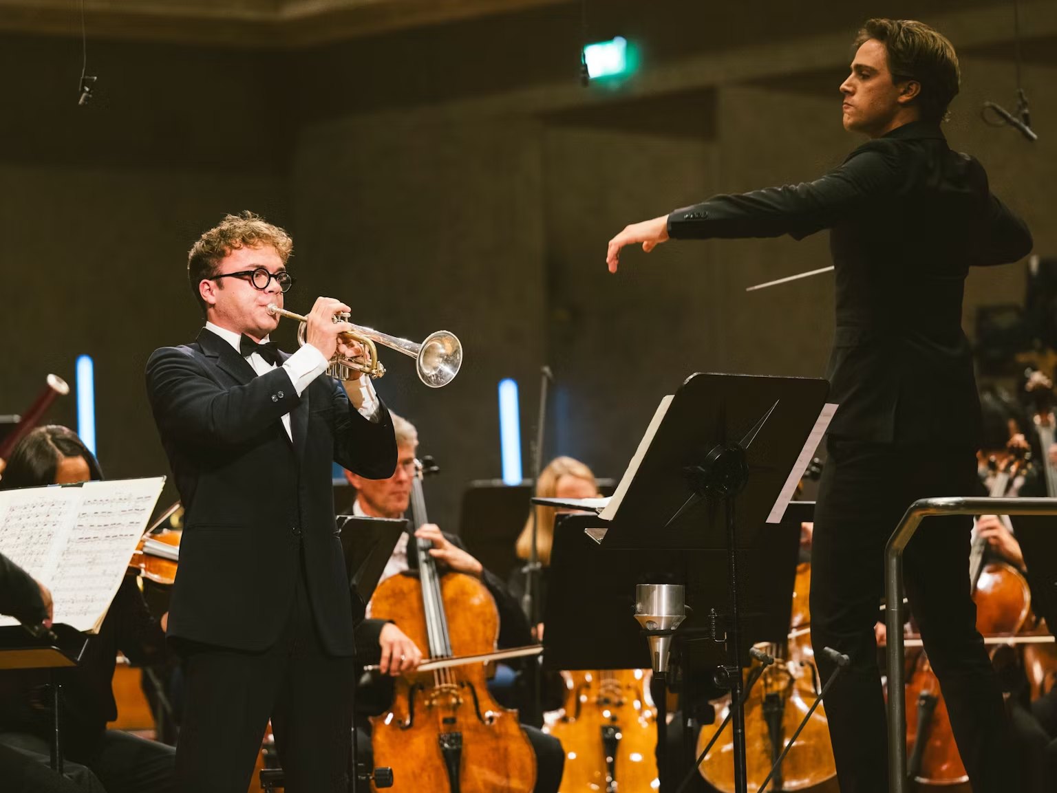 Sasha Scolnik-Brower conducting a trumpet soloist and orchestra